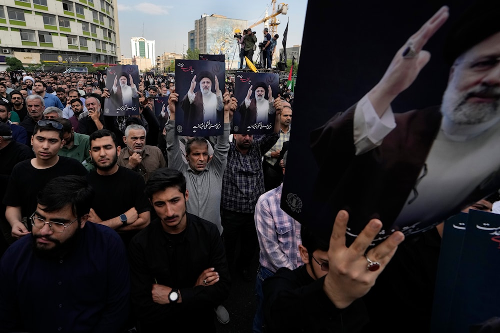 People hold up posters of Iranian President Ebrahim Raisi during a mourning ceremony for him at Vali-e-Asr square in downtown Tehran, Iran, May 20, 2024 (AP)