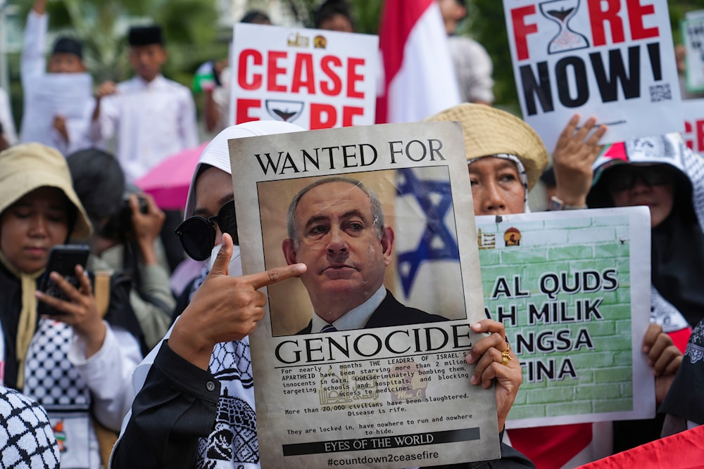 A protester holds a poster of Israeli Prime Minister Benjamin Netanyahu during a rally outside the US Embassy in Jakarta, Indonesia, May 17, 2024 (AP)