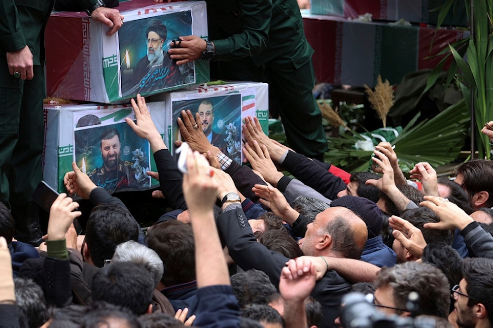 Mourners touch the coffins of President Ebrahim Raisi, Foreign Minister Hossein Amirabdollahian, and Raisi's chief bodyguard Gen. Mehdi Mousavi, in their funeral ceremony in the city of Tabriz, Iran, Tuesday, May 21, 2024 (AP)