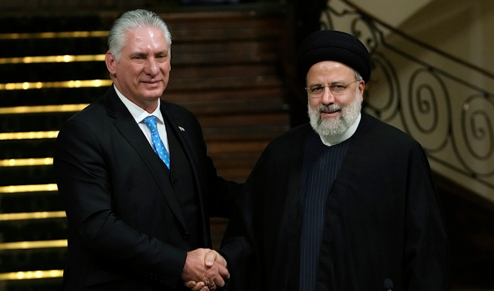 Iranian President Ebrahim Raisi, right, and his Cuban counterpart Miguel Díaz-Canel shake hands at the conclusion of a news briefing after their meeting at the Saadabad Palace in Tehran, Iran, Monday, Dec. 4, 2023. (AP)