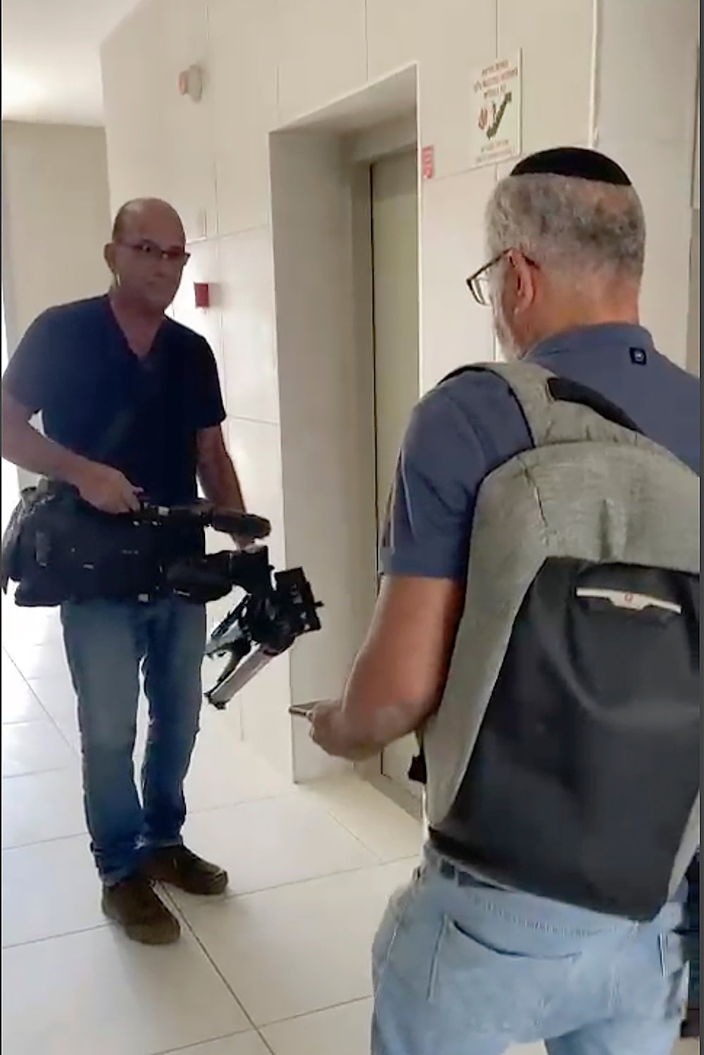 In this image from video, Israeli officials seize AP video equipment from an apartment block in Sderot, occupied Palestine, May 21, 2024 (AP)