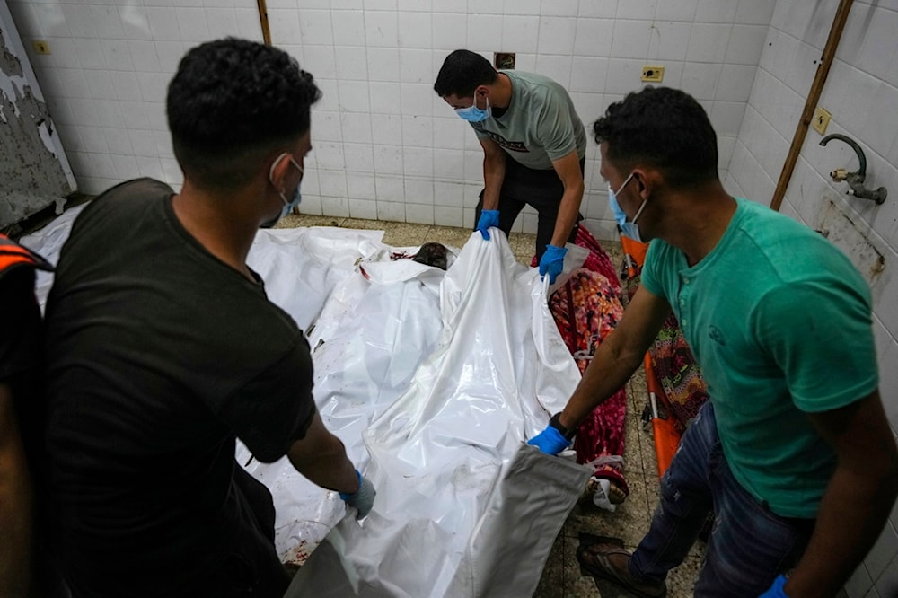 Palestinians carry the bodies of their relatives killed in the Israeli bombardment of Al Zawayda in central Gaza Strip, at the morgue of Al Aqsa hospital in Deir al Balah, Gaza Strip, early Wednesday, May 22, 2024. (AP)