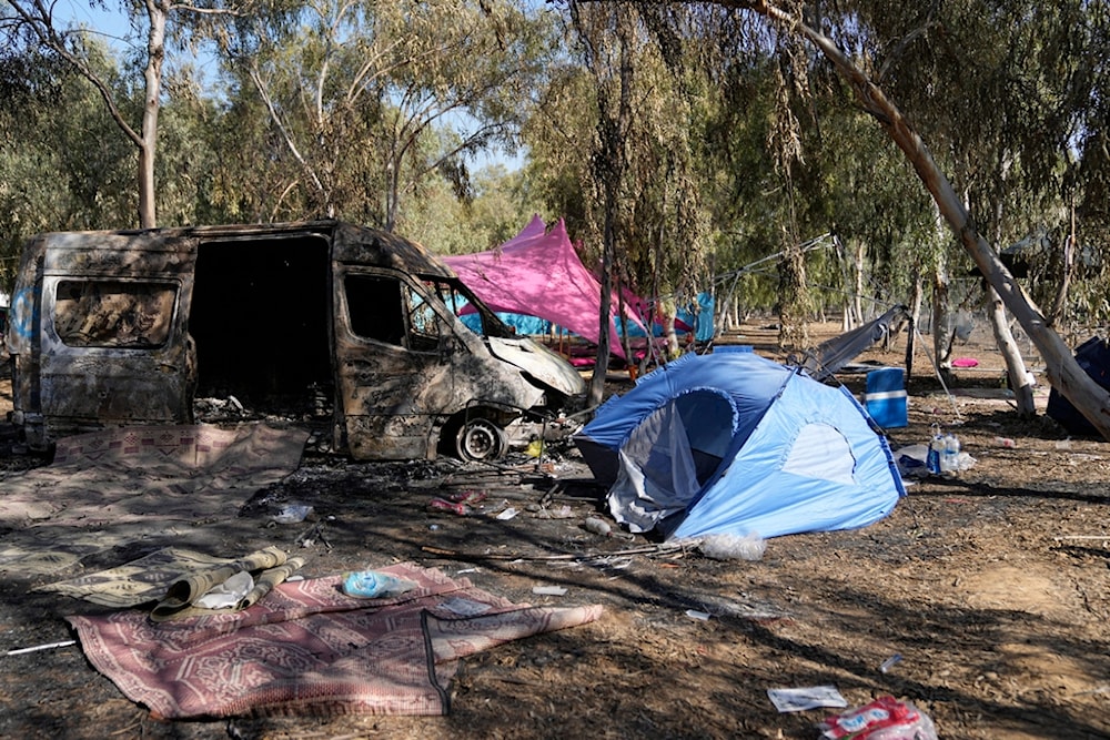 Tents, debris, and a burned-out van are scattered about the site of a music festival near the border with the Gaza Strip in southern occupied Palestine on Thursday, Oct. 12, 2023. (AP)
