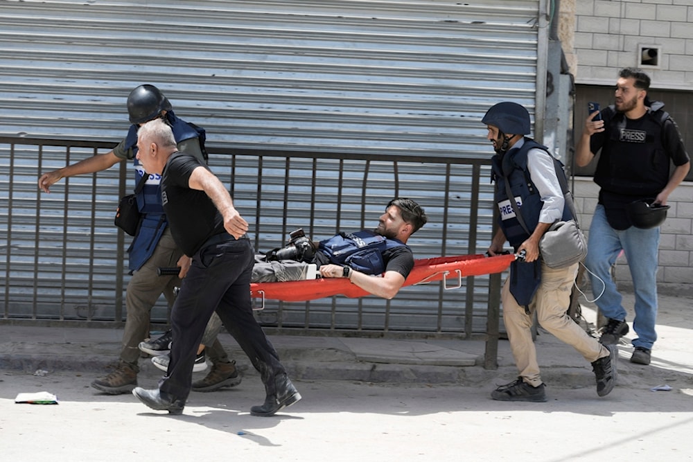 Journalists carry their colleague after he was shot in his leg during an Israeli military raid in the West Bank Jenin refugee camp, Tuesday, May 21, 2024.  (AP)