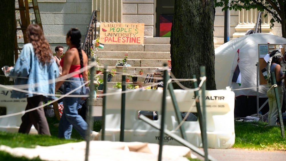 People walk past the remnants of an encampment of tents in Harvard Yard on the campus of Harvard University, Tuesday, May 14, 2024, in Cambridge, Mass. (AP)