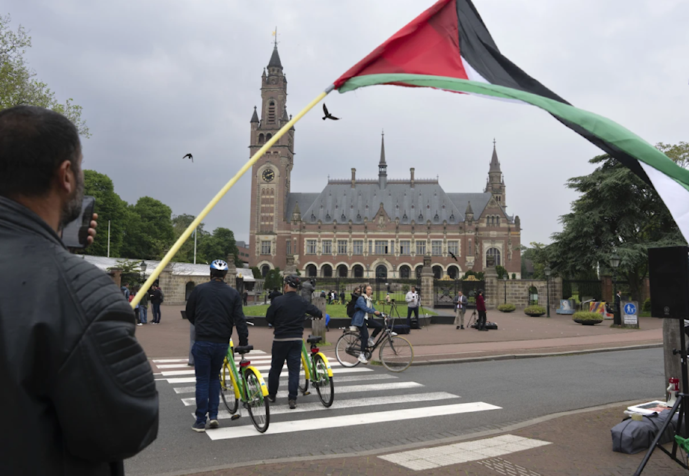 A demonstrator waves the Palestinian flag outside the Peace Paalace, housing the ICJ in The Hague, Netherlands on May 24, 2024. (AP)