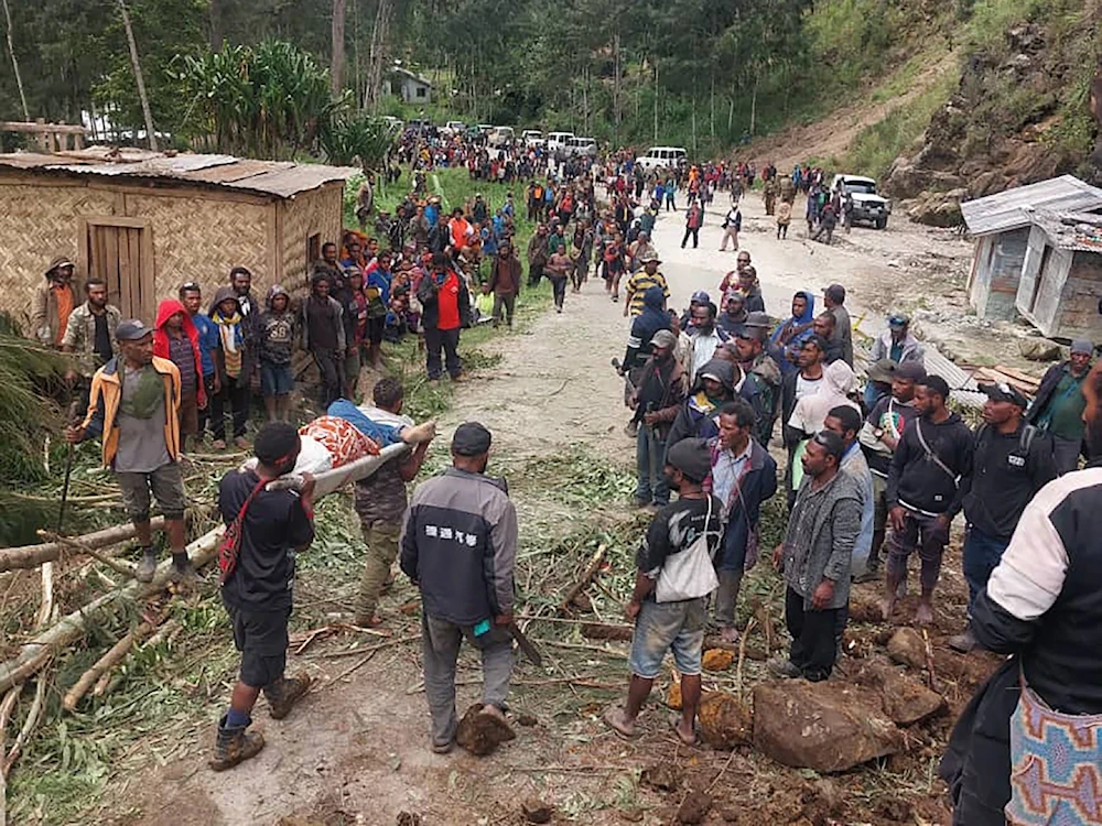 In this photo provided by the International Organization for Migration, an injured person carried on a stretcher after a landslide in Yambali village, Friday, May 24, 2024. ( International Organization for Migration via AP)