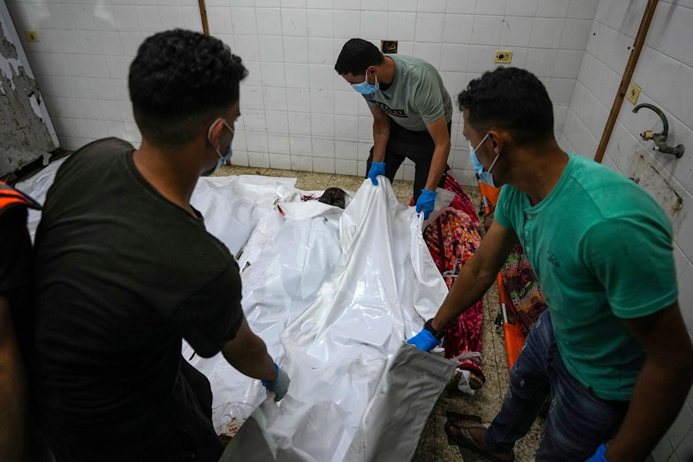 Palestinians carry the bodies of their relatives killed in the Israeli bombardment of Al Zawayda in central Gaza Strip, at the morgue of Al Aqsa hospital in Deir al Balah, Gaza Strip, on May 22, 2024. (AP)