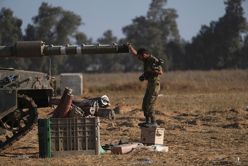 An Israeli soldier works on a tank near the Gaza border in southern occupied Palestine, Friday, May 24, 2024. (AP)