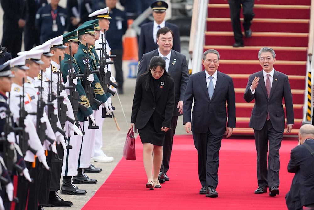 Chinese Premier Li Qiang, second right, is welcomed by South Korean 1st Vice Minister Kim Hong-kyun, as the premier arrives for a trilateral meeting, at the Seoul airport in Seongnam, South Korea, May 26, 2024 (AP)