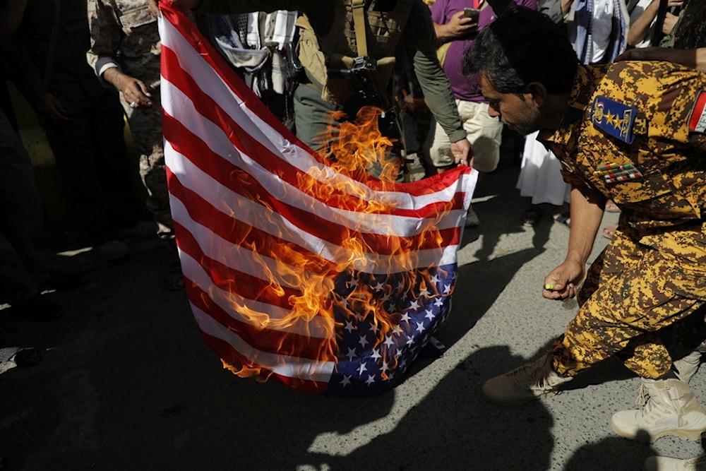 Houthi supporters burn an U.S. flag during a military march marking the anniversary of Yemeni unity in Sanaa, Yemen, Wednesday, May 22, 2024. (AP)