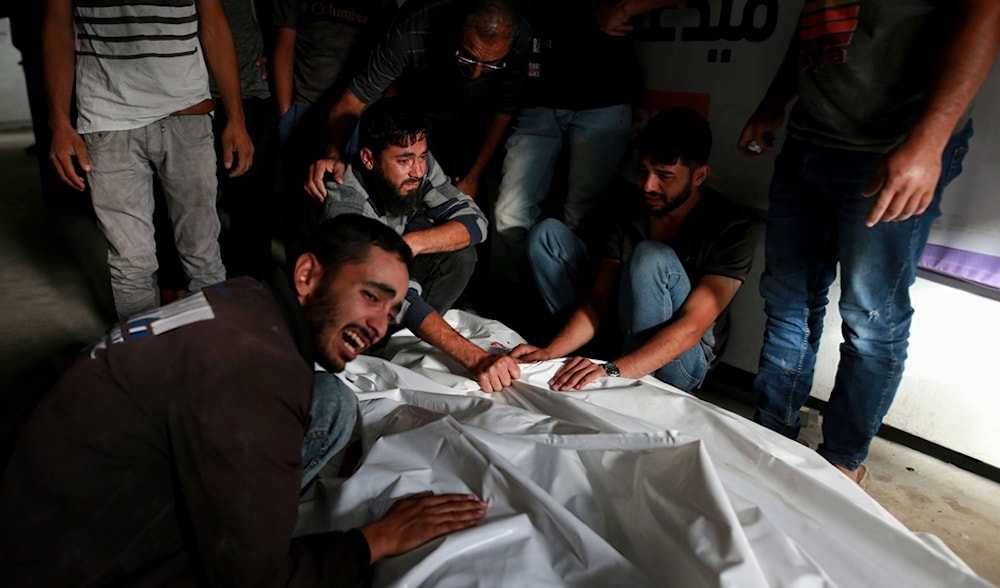Palestinians mourn over the bodies of relatives killed in an Israeli airstrike in Rafah, Gaza Strip, Monday, May 27, 2024. (AP)