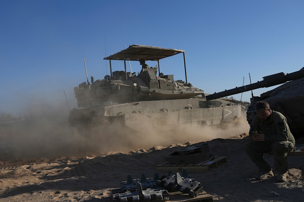Israeli occupation forces drive a tank in a staging area near Gaza, southern occupied Palestine, May 24, 2024 (AP)