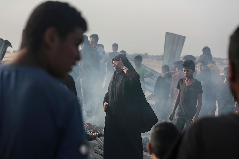 Palestinians look at the destruction after an Israeli strike where displaced people were staying in Rafah, Gaza Strip, occupied Palestine, May 27, 2024 (AP)