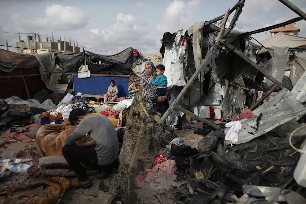 Displaced Palestinians inspect their tents destroyed by Israeli bombardment, adjunct to an UNRWA facility west of Rafah city, Gaza Strip, occupied Palestine, May 28, 2024 (AP)