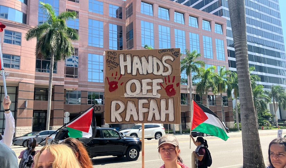 A protester holding a banner during a protest in Fort Lauderdale, Florida, against the Israeli massacre in Rafah (X/@drgloryjjjjj958)