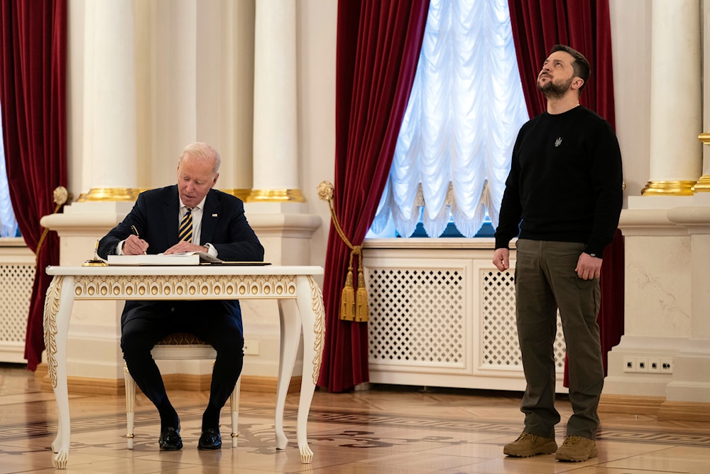 US President Joe Biden signs a guest book during his meeting with Ukrainian President Volodymyr Zelensky at the Mariinsky Palace during an unannounced visit in Kiev, Ukraine, Monday, Feb. 20, 2023. (AP)