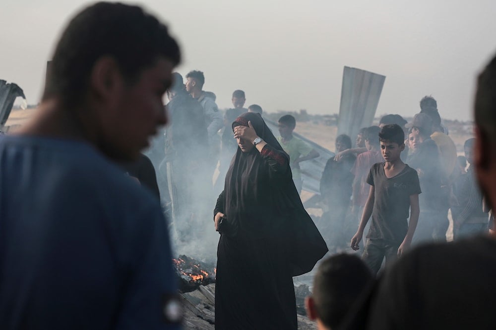 Palestinians look at the destruction after an Israeli strike where displaced people were staying in Rafah, Gaza Strip, Monday, May 27, 2024 (AP)