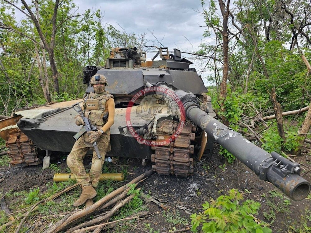 Russian soldier poses next to a destroyed M1 Abrams tank on the Western front on May 29, 2024 (Social media)