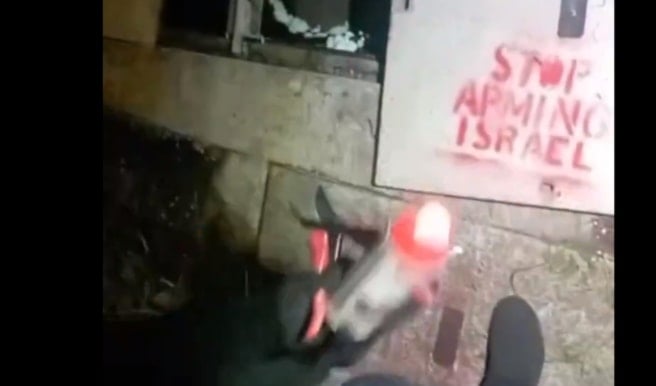 A screenshot of the Palestine Action activists spray painting on the electric cable cabinet of the Leonardo factory in Scotland on May 29, 2024 (X/@Pal_Action)