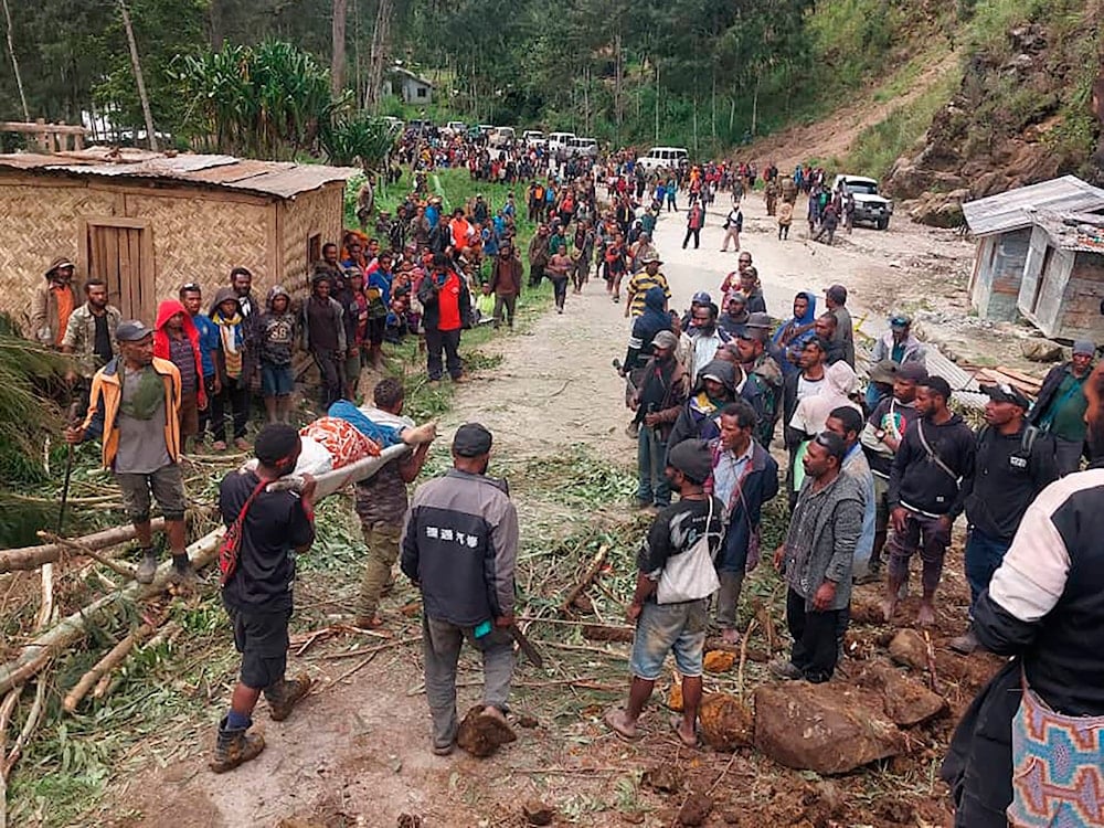 In this photo by the International Organization for Migration, an injured person is carried on a stretcher after a landslide in Yambali village, Papua New Guinea, Friday, May 24, 2024.