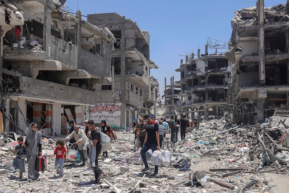 Palestinians walk through the destruction in the wake of an Israeli air and ground offensive in Jabalia, northern Gaza Strip, May 30, 2024 (AP)