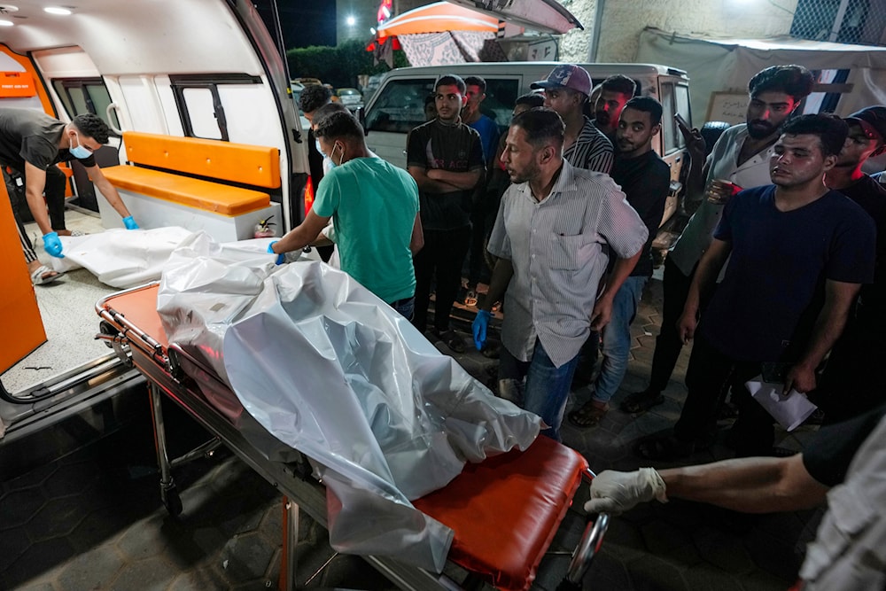 Palestinian medics move dead bodies killed in the Israeli bombardment of al-Zawaida in the central Gaza Strip to the morgue of al-Aqsa Hospital in Deir al Balah, Gaza Strip, occupied Palestine early Wednesday, May 22, 2024 (AP)