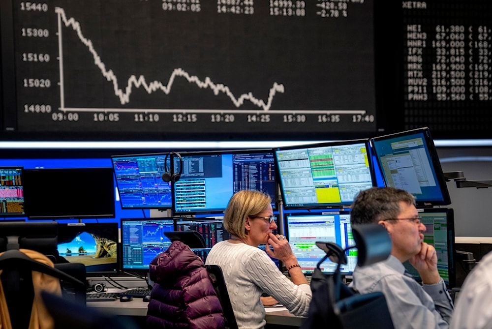 Brokers watch their screens at the stock market in Frankfurt, Germany, Monday, March 13, 2023. In background the curve of the German stock index DAX. (AP Photo/Michael Probst)