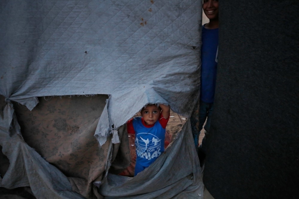 A Palestinian child living in a tent in Rafah after being forcibly displaced with his family amid the Israeli genocide (UNRWA)