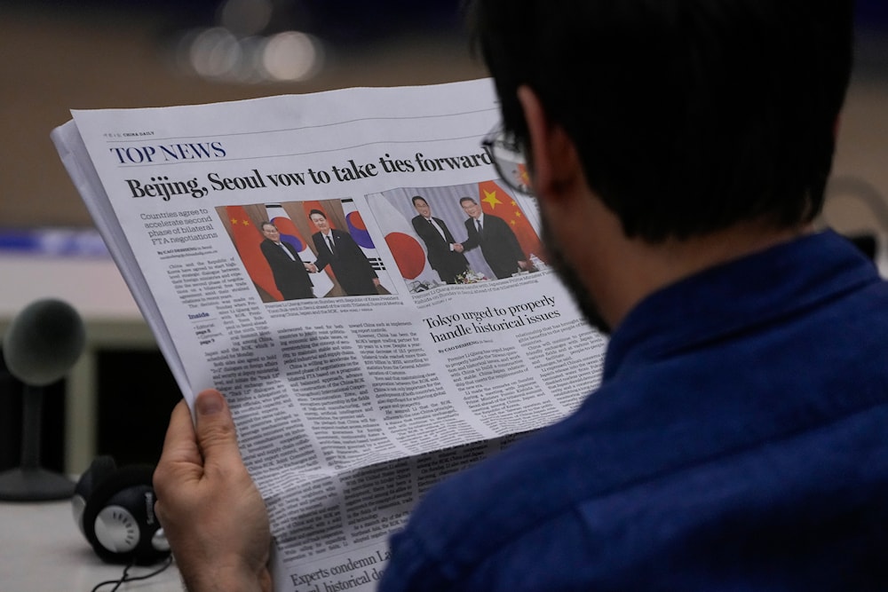 A journalist reads a local newspaper at the Ministry of Foreign Affairs office in Beijing, Monday, May 27, 2024. (AP)