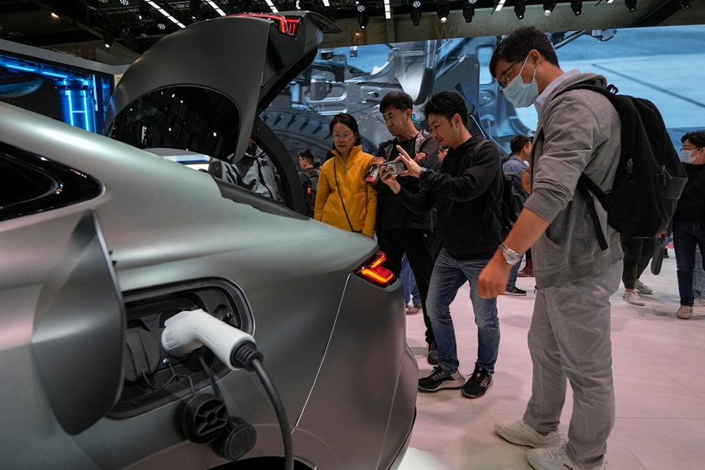 Visitors look at a Geely Galaxy E8 car during the Auto China 2024 in Beijing, Sunday, April 28, 2024. (AP)