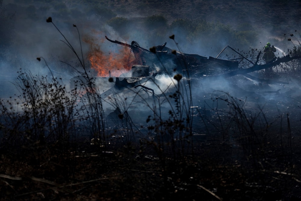 Israeli firefighters extinguish a fire burning in an area near the settlement of Ramot Naftali, by the border with Lebanon, northern occupied Palestine, Tuesday, June 4, 2024 (AP)