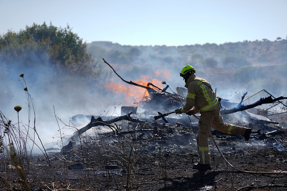 An Israeli firefighter works to extinguish a fire burning in an area near the community of Ramot Naftali, by the border with Lebanon, northern Israel, Tuesday, June 4, 2024. (AP)