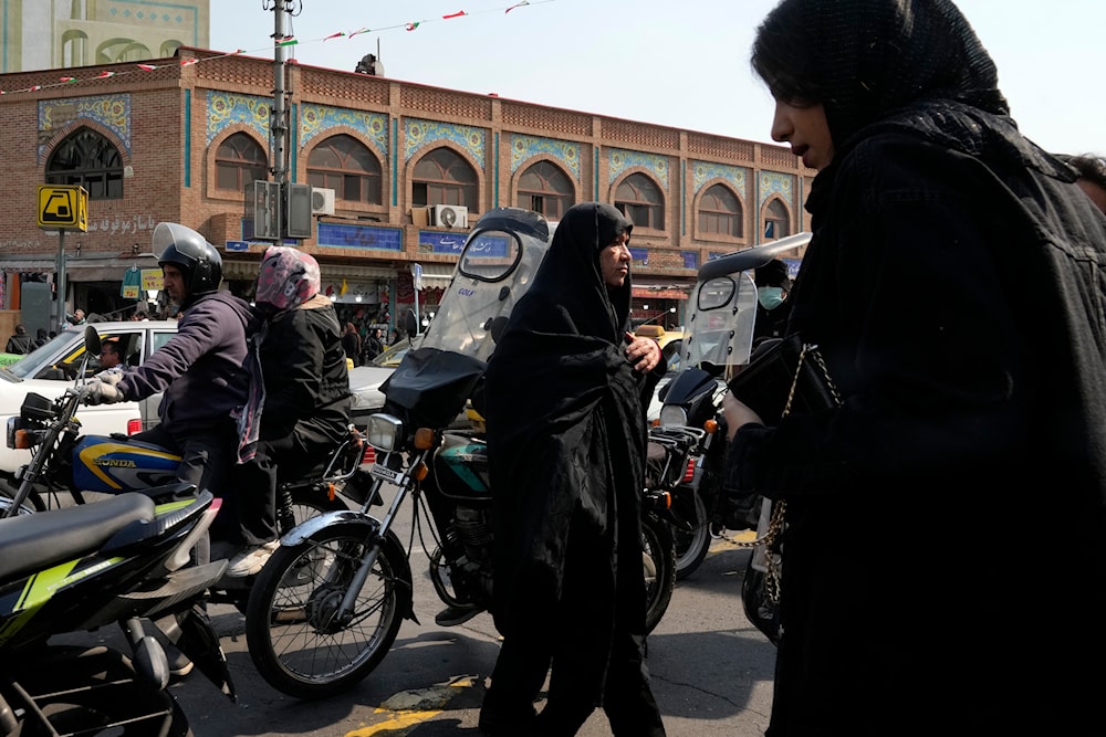 People cross an intersection in downtown Tehran, Iran, March 2, 2024 (AP)