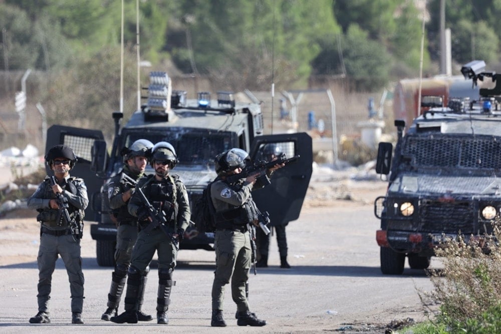 Israeli occupation forces take position outside the Ofer prison between Ramallah and Beitounia in the occupied West Bank, on November 24, 2023. (AFP)