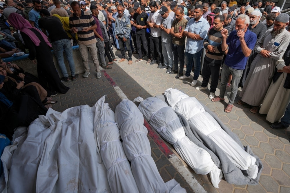 Mourners pray over the bodies of Palestinians who were killed in an Israeli airstrike in Nuseirat, at the al-Aqsa hospital in Deir al-Balah, Gaza Strip, Sunday, May 19, 2024. (AP)
