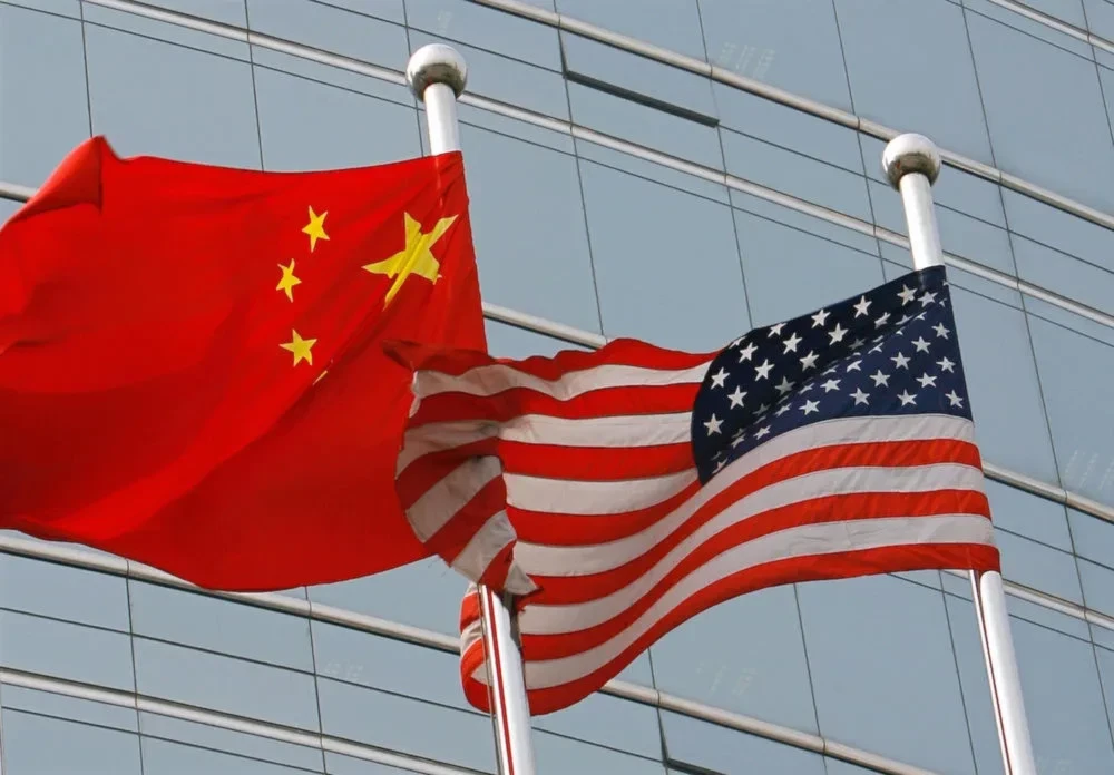 A US and a Chinese flag wave outside a commercial building in Beijing on July 9, 2007. (AFP/Getty Images)