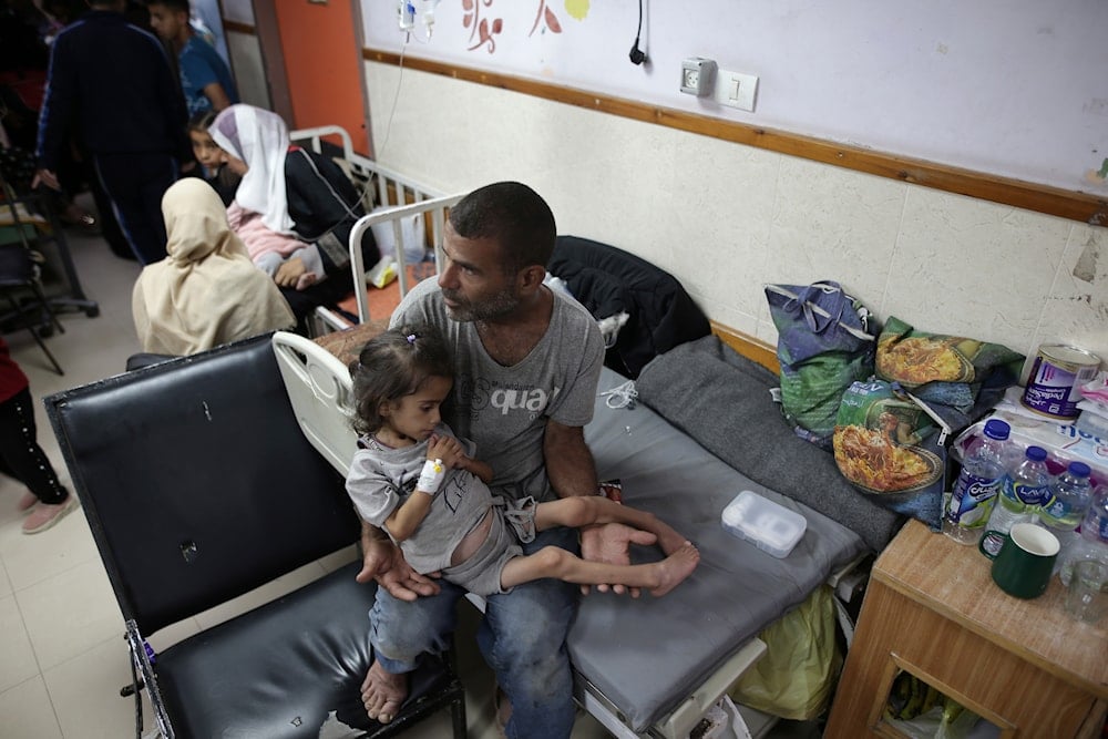 Abdulrahman Al-Rai holds his daughter Hana Al-Rai, 3, who suffers from diabetes, a weakened immune system and malnutrition at Al-Aqsa Martyrs Hospital in Deir al-Balah in the central Gaza Strip, where she is receiving treatment, on June 1, 2024. (AP)