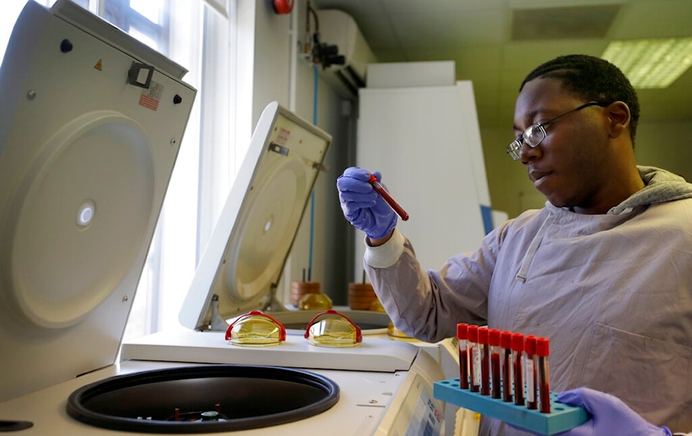 Leon McFarlane a research technician uses a centrifuge on blood samples from volunteers in the laboratory at Imperial College in London, Thursday, July 30, 2020. (AP)