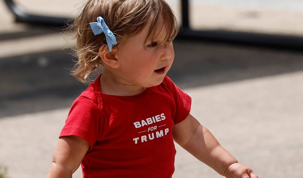 A baby runs before Republican presidential candidate former President Donald Trump speaks at a campaign event Tuesday, June 18, 2024, in Racine, Wis. (AP)