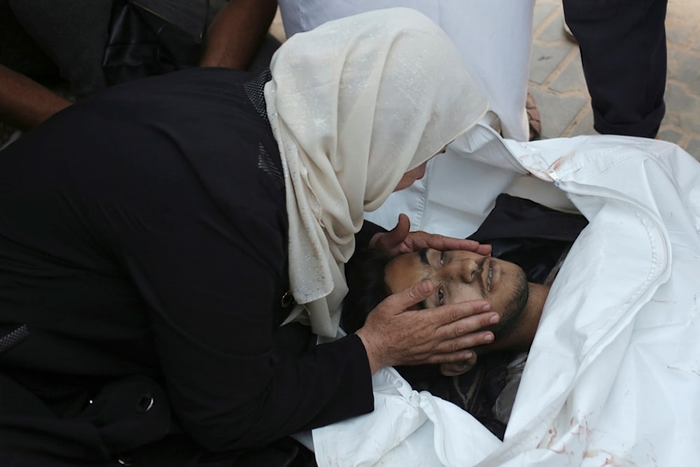 A Palestinian woman takes a last look at a loved one killed by Israeli bombardment, before his burial in Khan Younis, southern Gaza Strip, Friday, June 21, 2024. (AP)