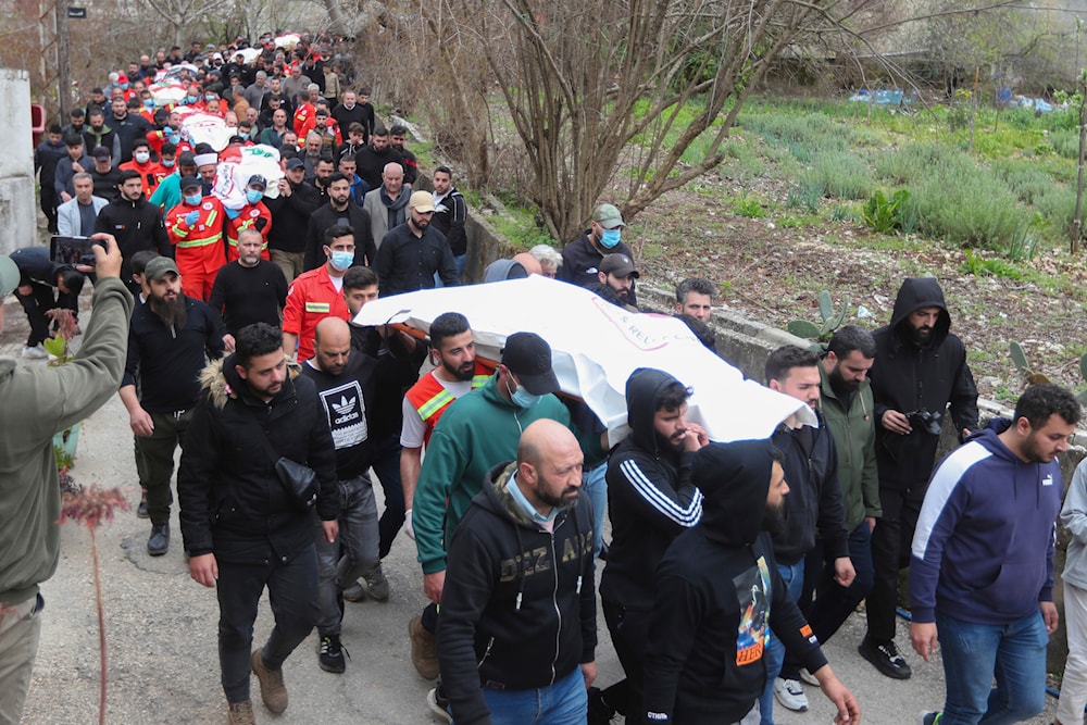 People carry the coffins of paramedics who were killed in an Israeli airstrike, during a funeral procession in Hebbariye village, south Lebanon, March 27, 2024 (AP)