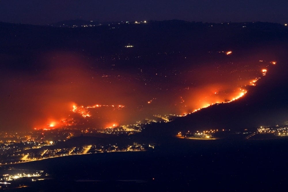 Fires burn around and in Kiryat Shmona near the Palestinian-Lebanese border, in occupied al-Jalil Panhandle, occupied Palestine, on June 3, 2024. (AFP)