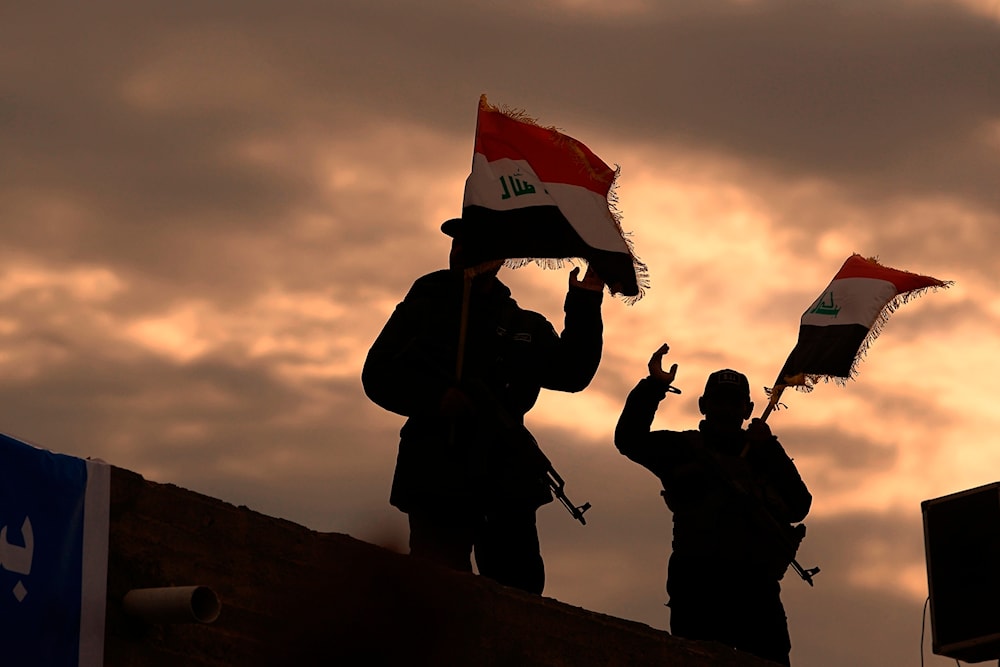 Fighters with Iran-backed militias in Iraq known as the Popular Mobilization Forces, wave Iraqi flag