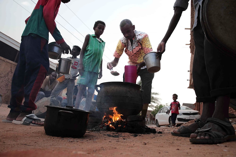 People prepare food in a Khartoum neighborhood on June 16, 2023. (AP)