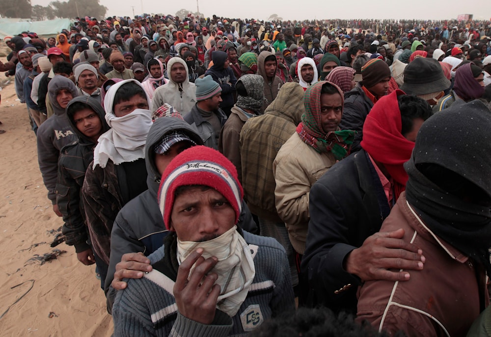 Migrant wait in line for food at a refugee camp on the Tunisia-Libyan border, in Ras Ajdir, Tunisia,on March 12, 2011. (AP)