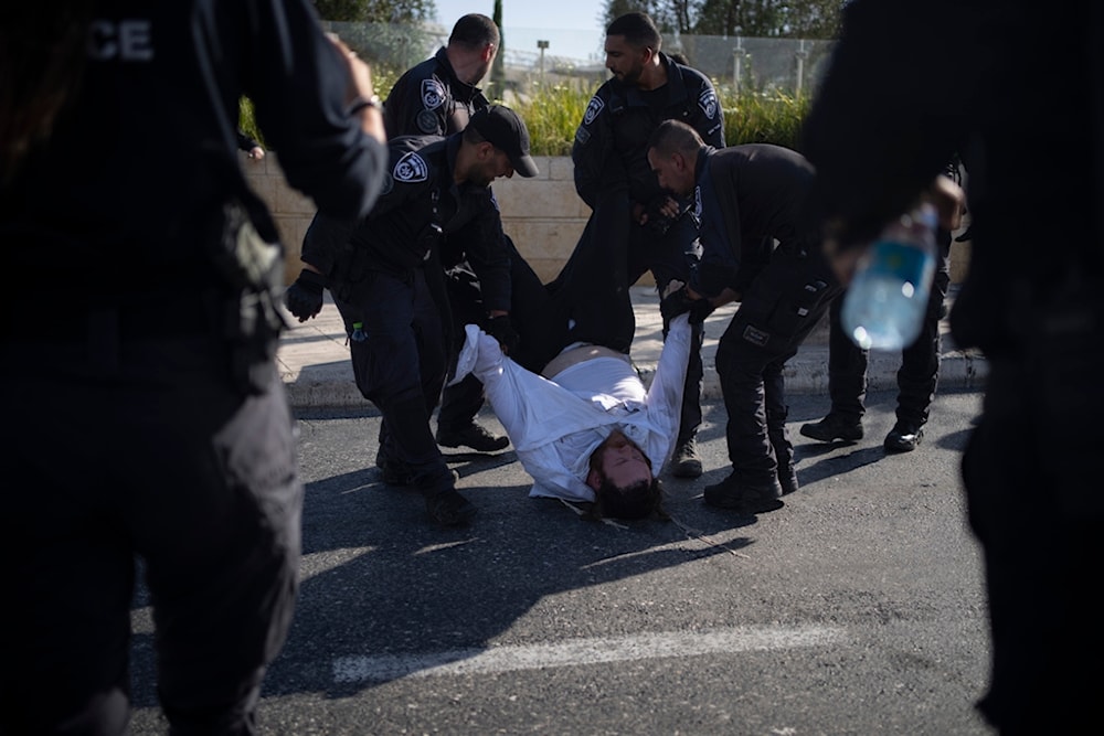  Israeli police officers remove an ultra-Orthodox Jewish man from the street during a protest against army recruitment in Jerusalem on June 2, 2024. (AP)