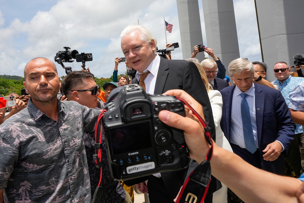 WikiLeaks founder Julian Assange, centre, is escorted to a vehicle as he leaves the federal court in Saipan, Mariana Islands, June 26, 2024 (AP)