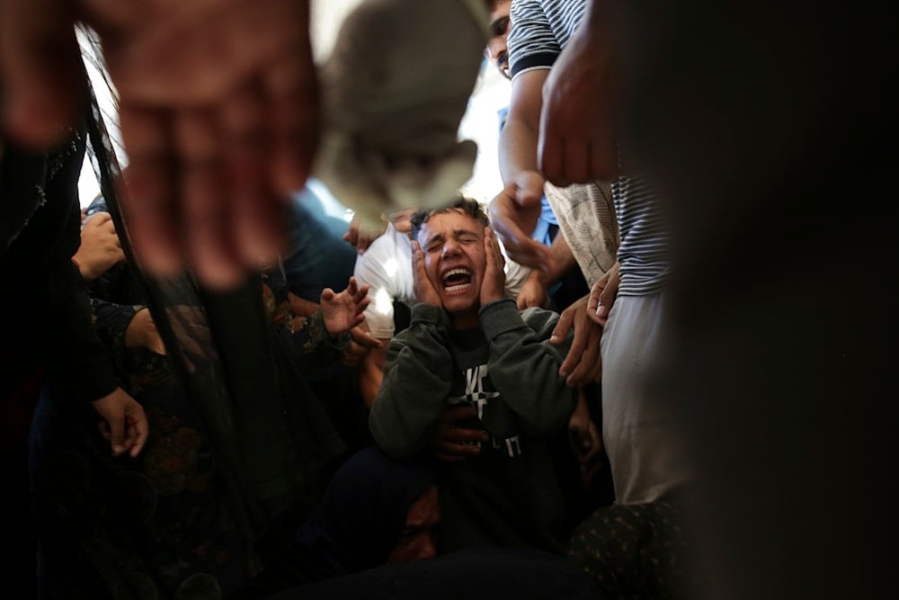 Palestinians mourn their relatives killed in the Israeli bombardment of the Gaza Strip at a hospital morgue in Khan Younis, southern Gaza Strip, Monday, June 24, 2024. (AP)