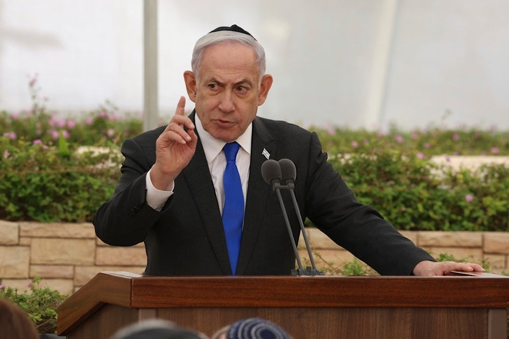 Israeli Prime Minister Benjamin Netanyahu speaks during a ceremony at the Nahalat Yitzhak Cemetery in occupied Palestine, Tuesday, June 18, 2024 (AP)